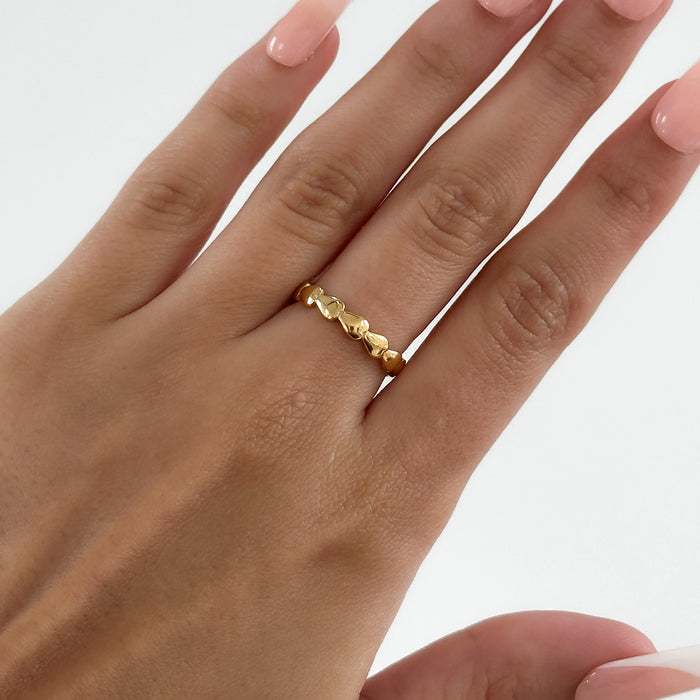 model wearing Harper Gold plated dainty Ring featuring a charming row of hearts, perfect for ring stacking