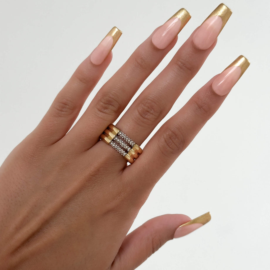 model wears Liana Ring featuring a chunky gold triple band paved with sparkling CZ stones from Prya