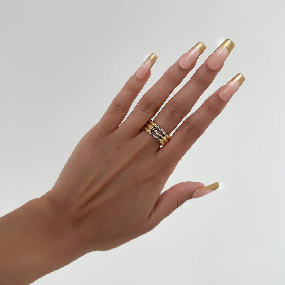 model wears Liana Ring featuring a chunky gold triple band paved with sparkling CZ stones from Prya