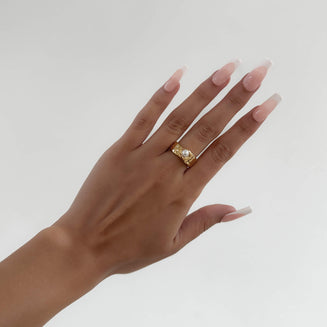 model wearing Nadine Pearl Ring, featuring a lustrous pearl set in a gold textured waved band from Prya