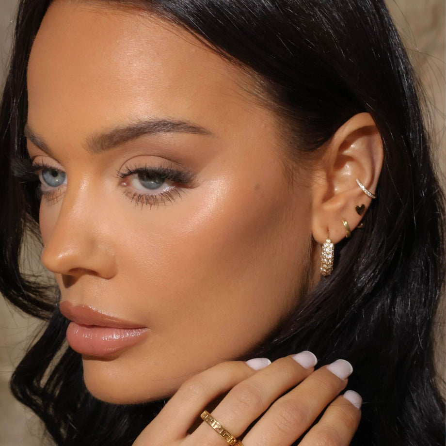 model wearing  stack of cz earrings including hoops, huggies, studs and cuffs from prya