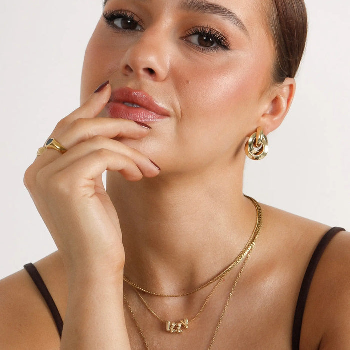 model wearing gold bubble charm necklace from Prya