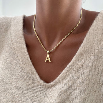 model wearing mini bubble initial necklace available in 18k gold or silver plated stainless steel from prya