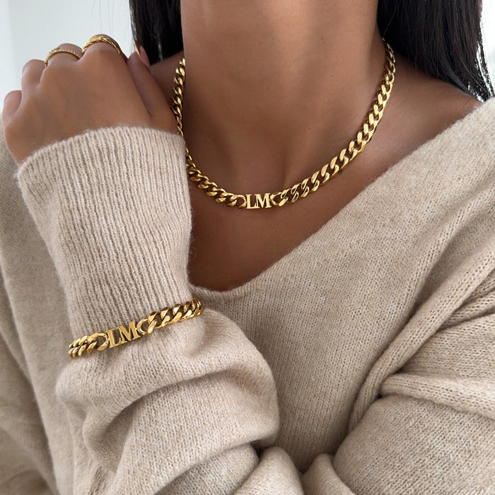 Model wearing the initial choker necklace and Initial bracelet in Gold and cuban chain