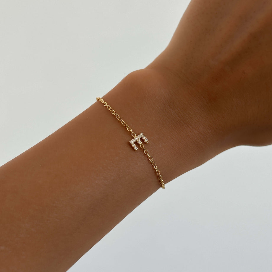 model wearing lana icy initial bracelet in 18k gold plated from prya