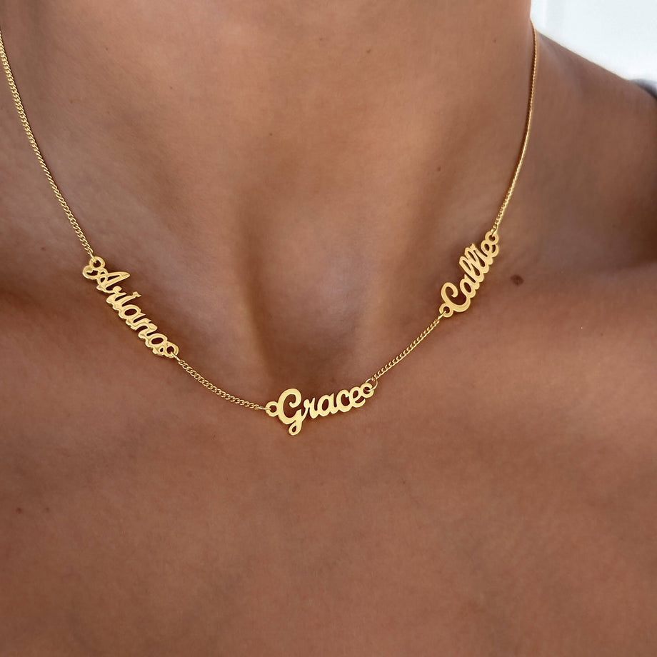 model wearing multiple Miami name necklace in gold from prya