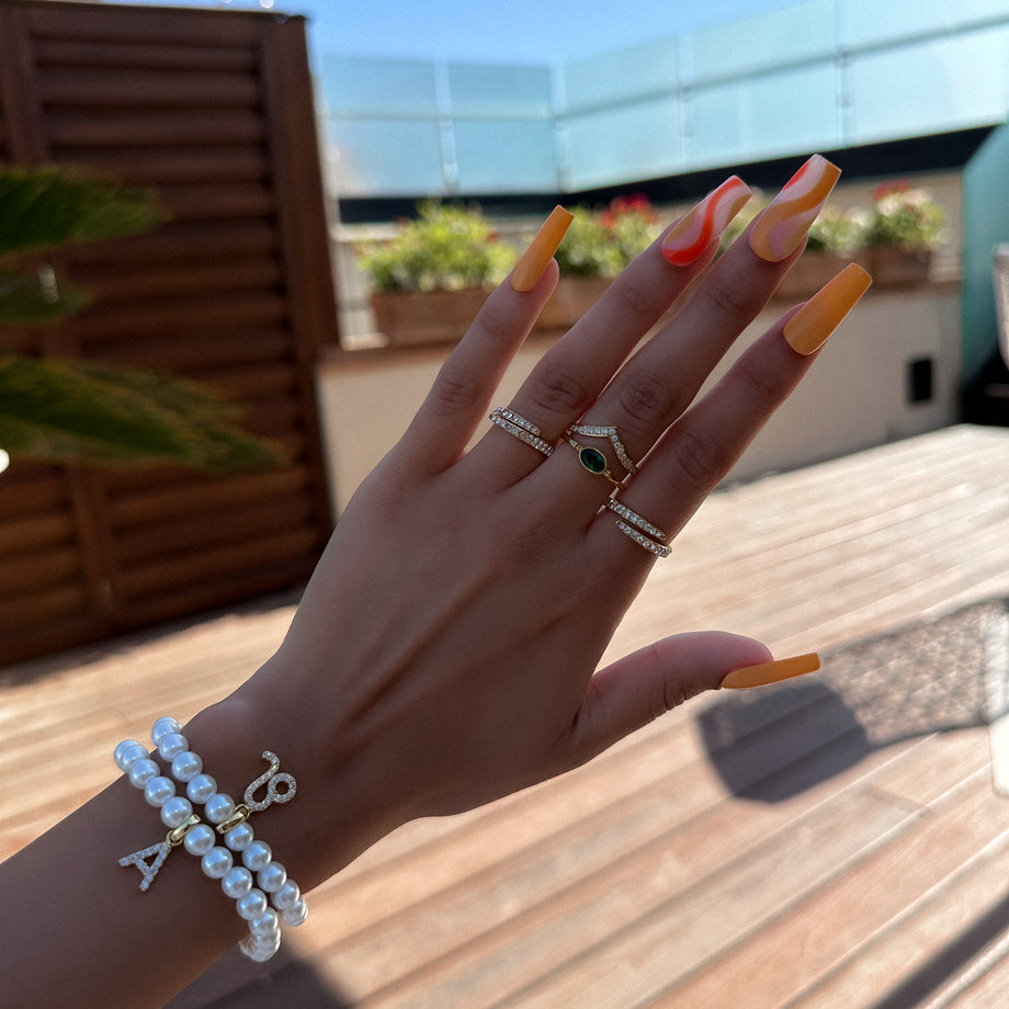 Model wearing a collection of ICY rings and pearl personalised bracelets 