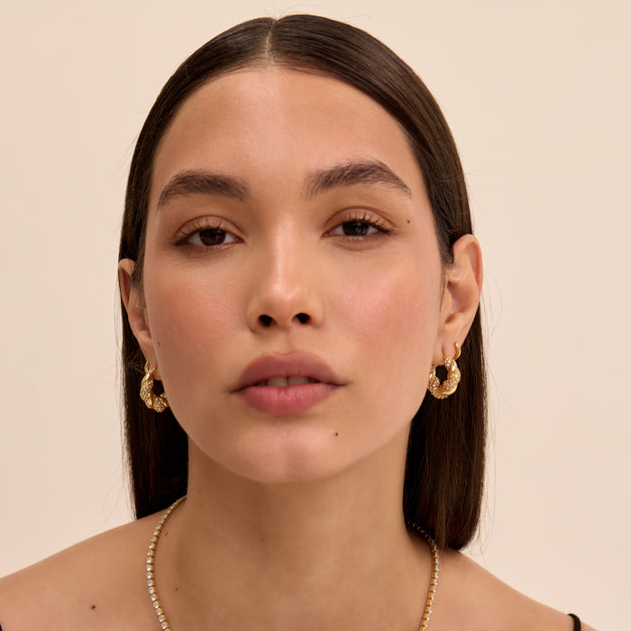model wearing gia twisted hoop earrings in pave gold from prya