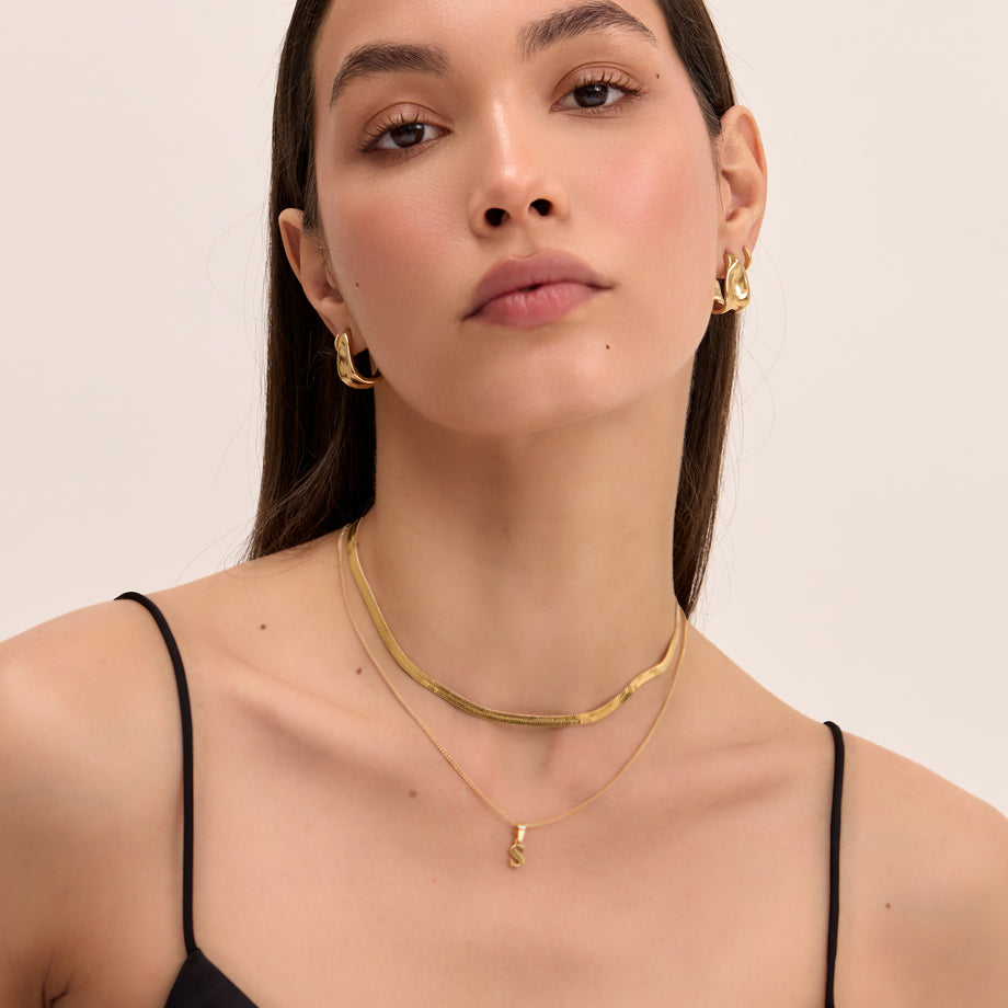 model wearing personalised  kayla lowercase initial necklace and herringbone gold necklace from prya