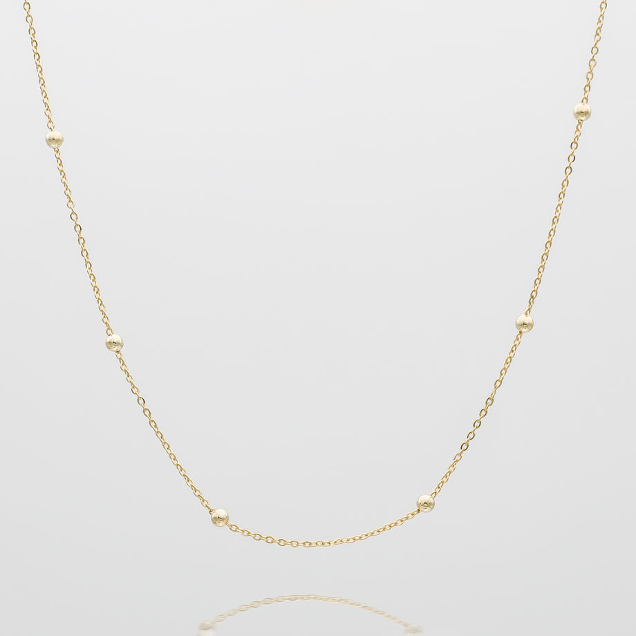Gold chain necklace with delicate spheres.