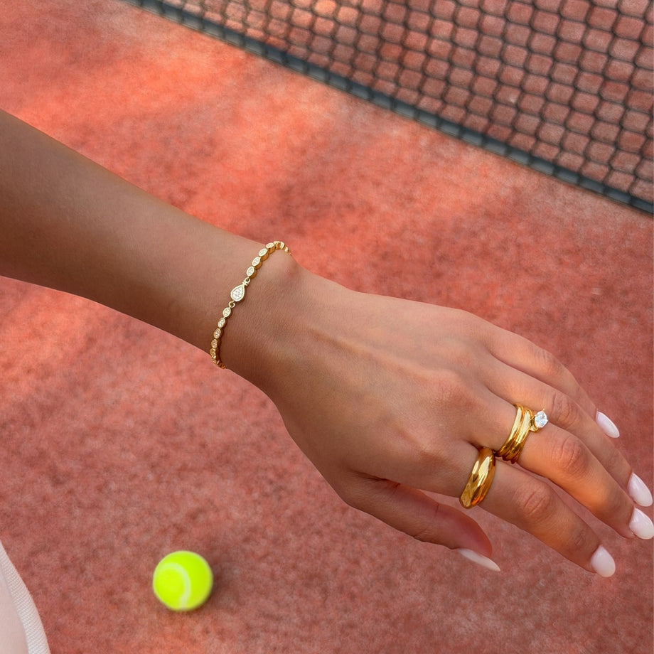model wearing padel bracelet in 18k gold vermeil with Oval stones and pavé padel racket charm.