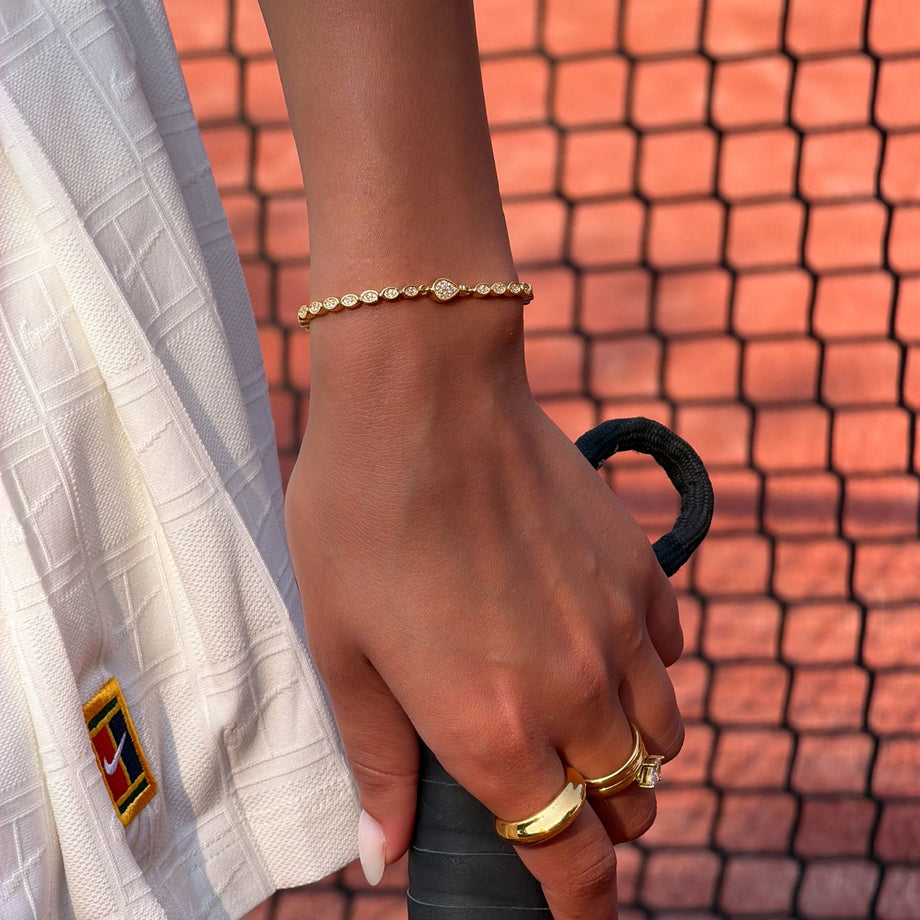 model wearing padel bracelet in 18k gold vermeil with Oval stones and pavé padel racket charm.