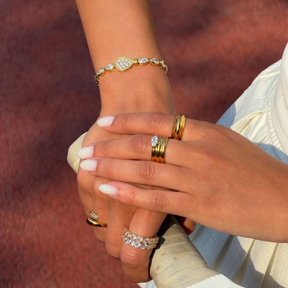 model wearing padel bracelet in 18k gold vermeil. Oval stones and pavé padel racket charm.