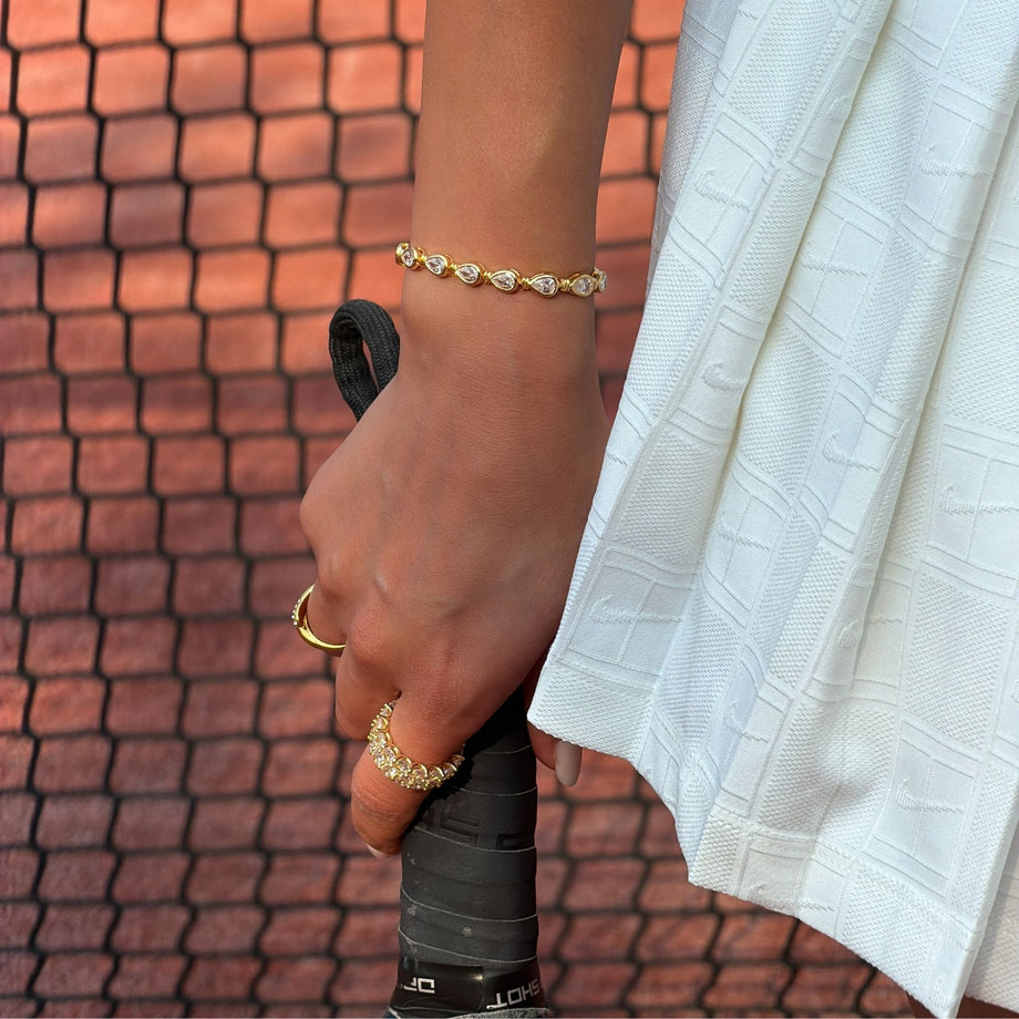 model wearing padel bracelet in 18k gold vermeil with Oval stones and pavé padel racket charm.