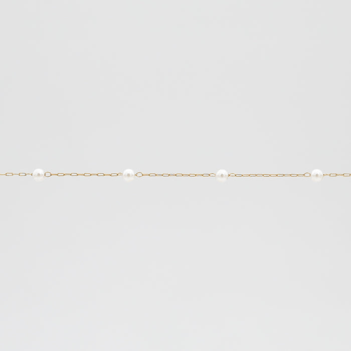 Gold chain with evenly spaced pearls.