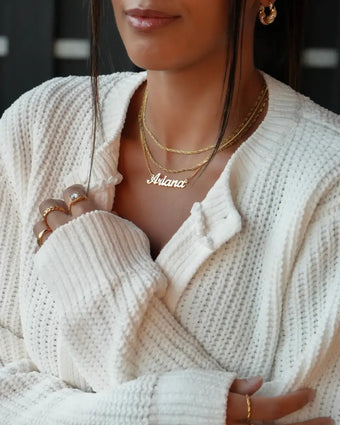 Model wearing plated 18k Gold personalised name necklace and chains, and ring stacks from Prya