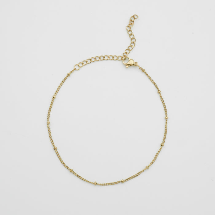 Gold anklet with delicate chain and clasp.