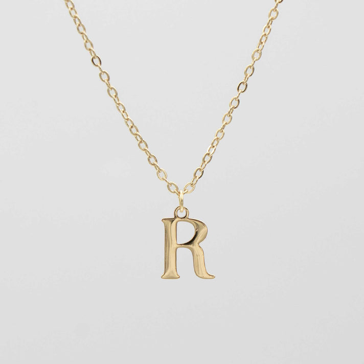 Gold plated initial necklace featuring the letter "R" on a delicate chain, perfect for personalization.