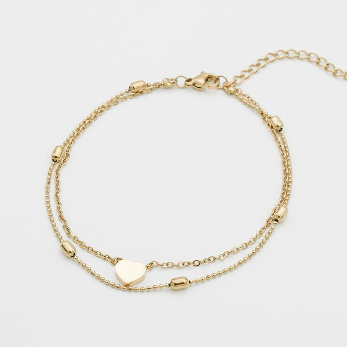 Gold anklet with heart charm and beads.