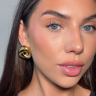 model wearing rania knot button earring in 18k gold plated from prya