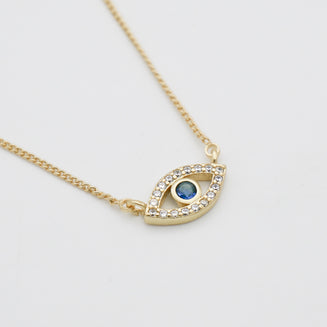 Close up of Gold Evil eye necklace paved with CZ and blue stone