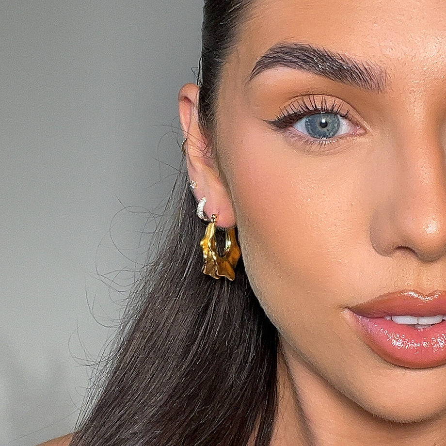 model wears The Ruba 18k Gold plated medium Hoop Earrings, featuring an embossed design from prya