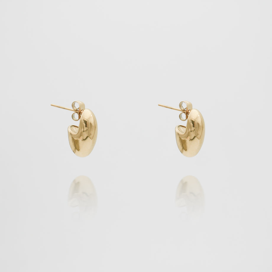 Two gold hoop earrings on white background.