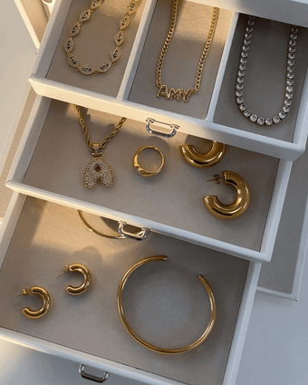 jewellery box filled with 18k gold plated jewellery from prya, chunky earrings, evil eye bracelet, chunky bangle, personalised name necklace, bubble theme and rings