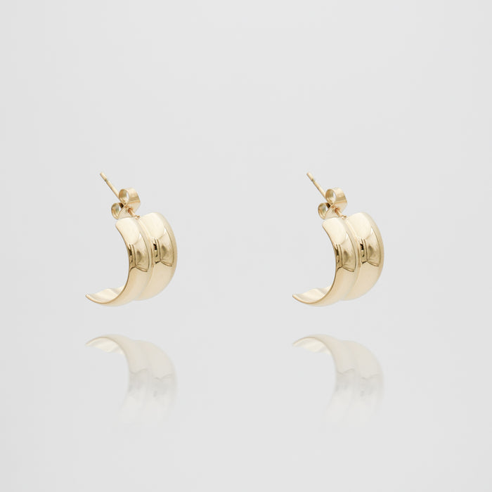 Gold hoop earrings on white background.