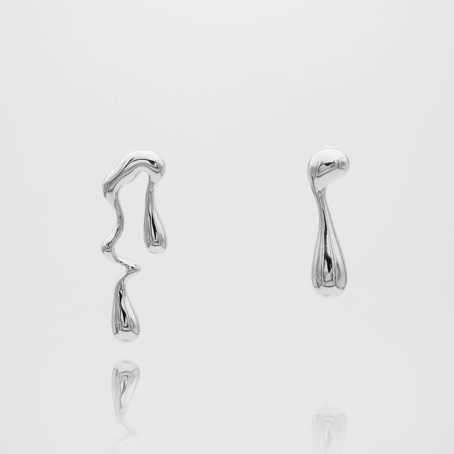 Abstract silver earrings on white background.