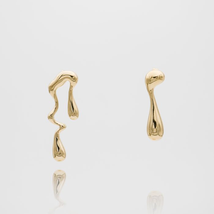 Abstract gold earrings on white background.