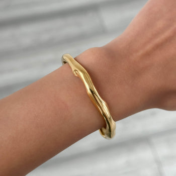 model wearing Thea Bangle, a minimalist textured 18k gold plated bracelet with a subtle wavy design from PRYA