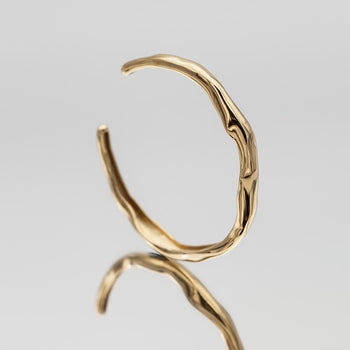 Thea Bangle, a minimalist textured 18k gold plated bracelet with a subtle wavy design from PRYA