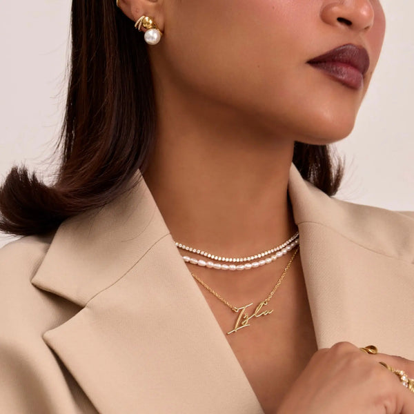 model wearing valencia custom name  in gold and pearl necklaces