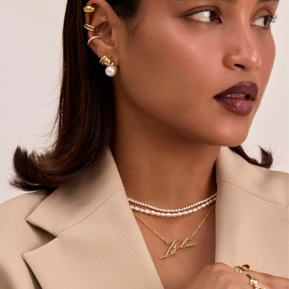 model wearing valencia custom name  in gold and pearl necklaces