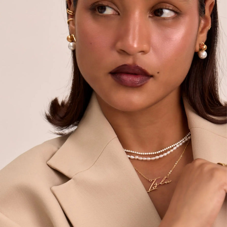 model wearing valencia custom name  in gold and pearl necklaces