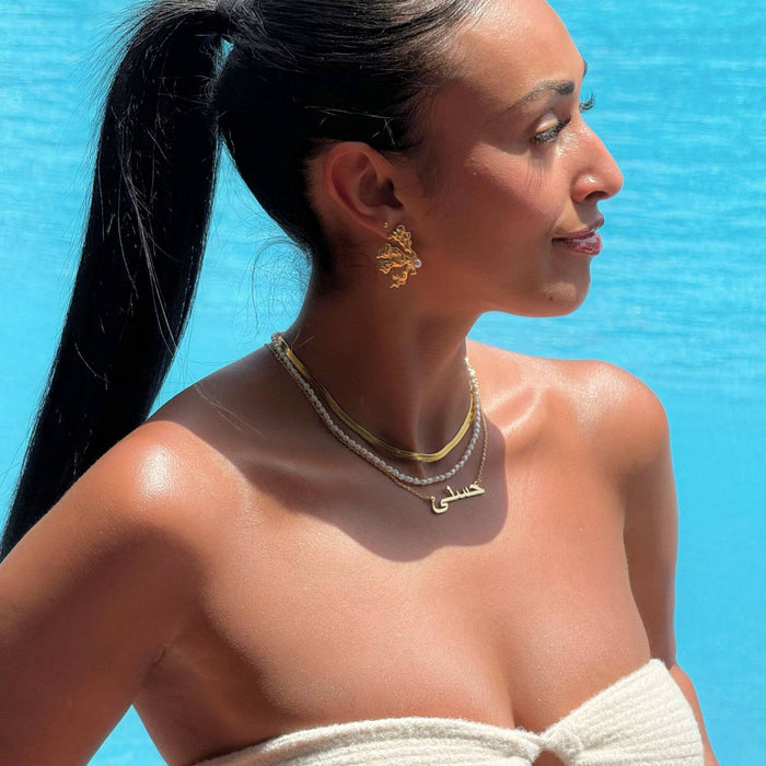 model in the pool wearing arabic name necklace in gold from prya