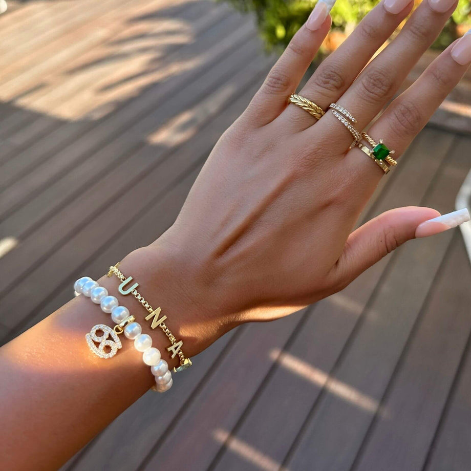 model wearing classic custom name bracelet, teamed up with rings and other bracelets from prya