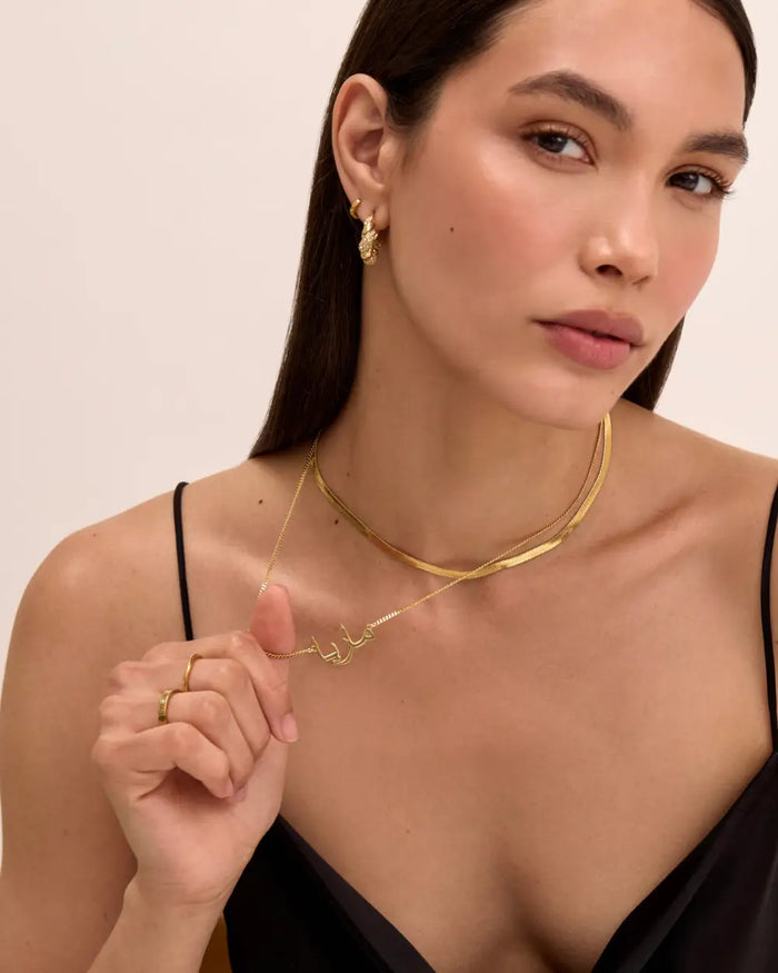 image of model wearing bestselling gold arabic name jewellery and herringbone necklace from prya
