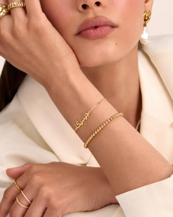 model wearing 18k gold plating custom name bracelet and beaded bracelet from prya