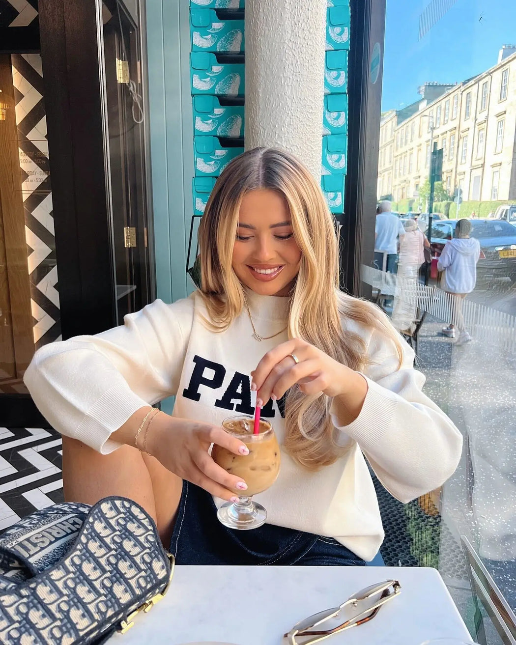image of model in a cafe wearing icy personalised name necklace from prya