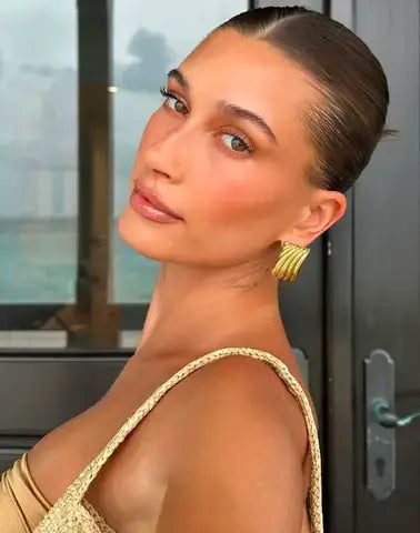 image of hailey beiber with gold statement earrings