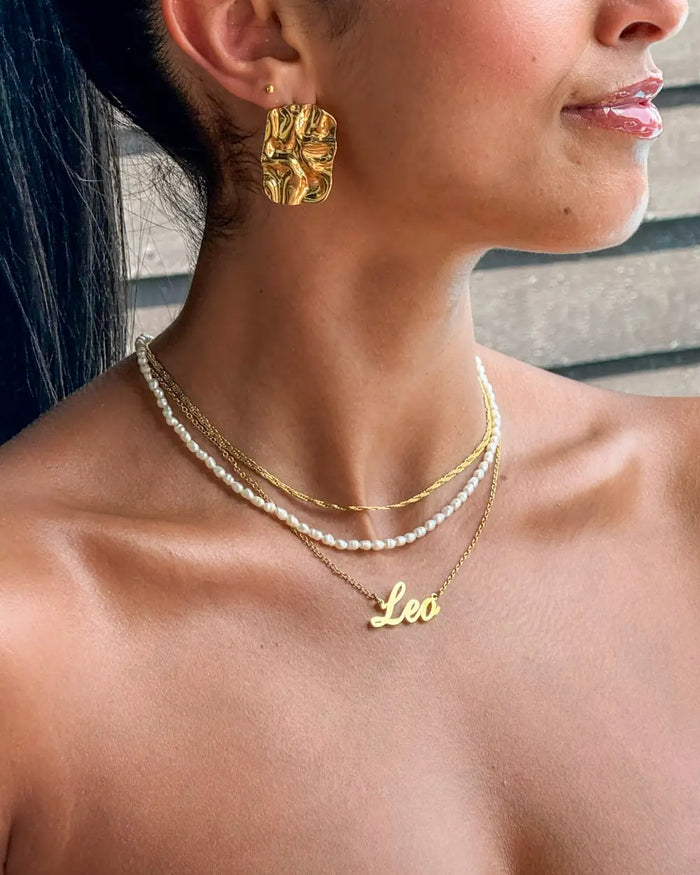 model wearing personalised zodiac jewellery in gold from prya