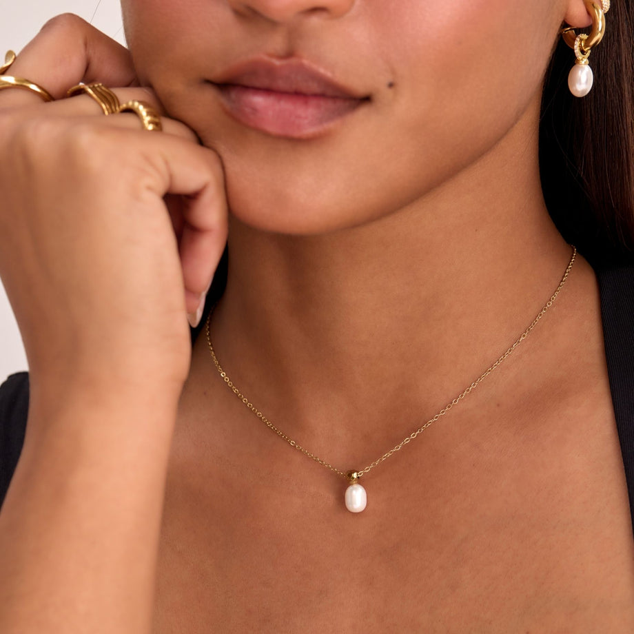 model wearing pearl drop necklace in gold from prya