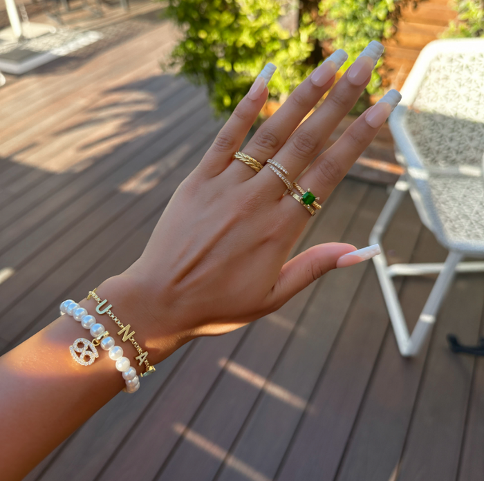 model wearing Gold-accented pearl bracelet with zodiac charm.