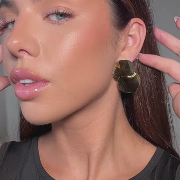video of model wearing gold statement drop earrings from prya