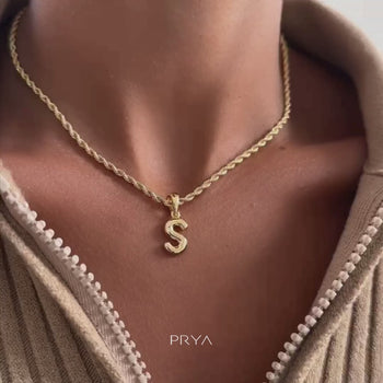 model wearing mini bubble initial necklace available in 18k gold or silver plated stainless steel from prya