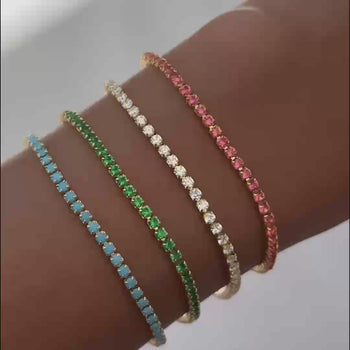 model wearing all four colours of the icy tennis cz bracelets in gold