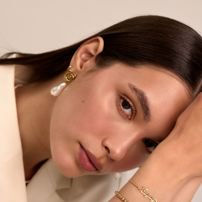 model wearing rumi pearl drop earrings in gold from prya