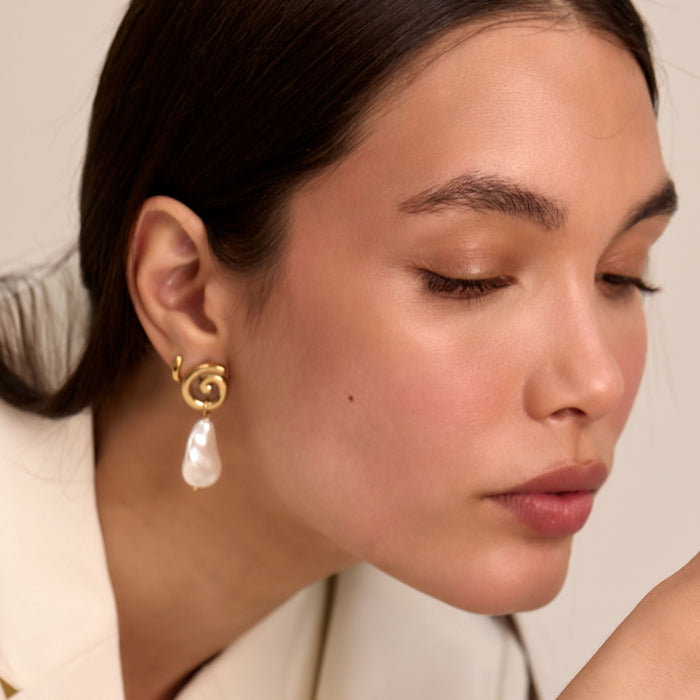 model wearing rumi pearl drop earrings in gold from prya